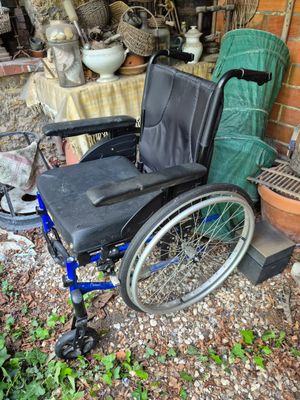 a wheel chair that is sitting in front of a brick wall