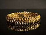 a close up of a gold bracelet on a black surface