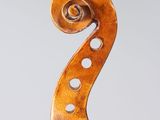 a close up of the back of a violin with a fiddle in the foreground