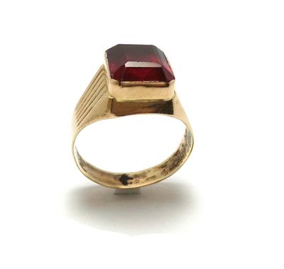 une image représentant une bague en or sertie d'une pierre rouge