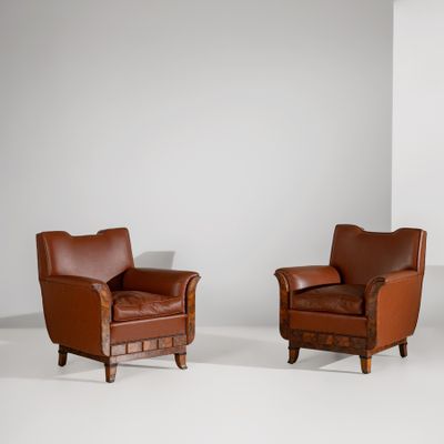 deux fauteuils en cuir marron dans une pièce blanche aux murs blancs