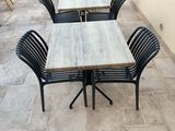 de nombreuses tables et chaises sur la terrasse à l'extérieur du bâtiment
