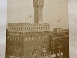 an old photo of a clock tower in the middle of a city