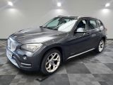 La BMW X1 est garée dans le garage, sur un sol à damier.