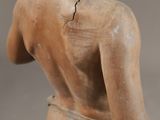 an old statue of a man with his back turned to the side