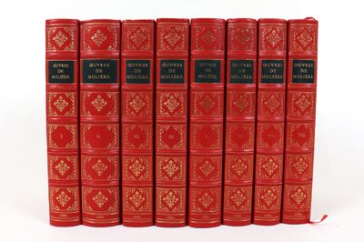 six livres rouges alignés sur une surface blanche