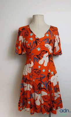 une robe orange à fleurs bleues et blanches, présentée sur un mannequin