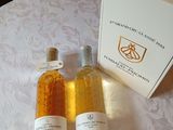 trois bouteilles de vin posées sur une table, à côté d'une boîte