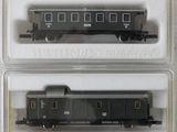 quatre wagons de train dans des conteneurs en plastique posés sur une surface blanche