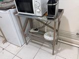 a microwave sitting on a table with a bottle of wine on top of it