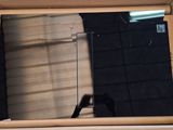 un miroir dans une boîte dans lequel se reflète une personne