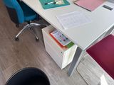 a desk with a computer and a chair in a room