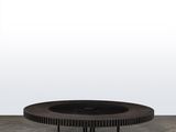 une photo d'une table basse ronde dans une pièce au sol en béton