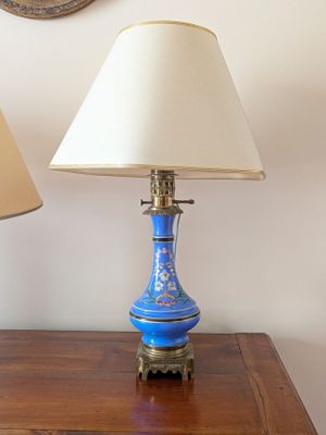 two lamps that are on a table with a mirror in the background