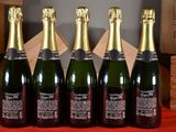six bottles of champagne are lined up on a table