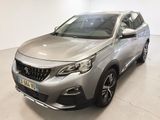 Une voiture argentée est garée dans une pièce blanche