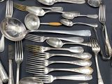 a lot of silver spoons and forks on a table