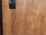 une armoire en bois avec une porte noire sur laquelle est apposée une pancarte