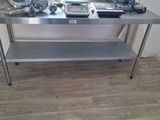 a stainless steel work table with a lot of tools on it