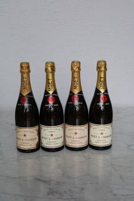 three bottles of champagne are lined up on a marble table