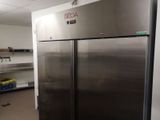 a large stainless steel refrigerator in a room with shelves
