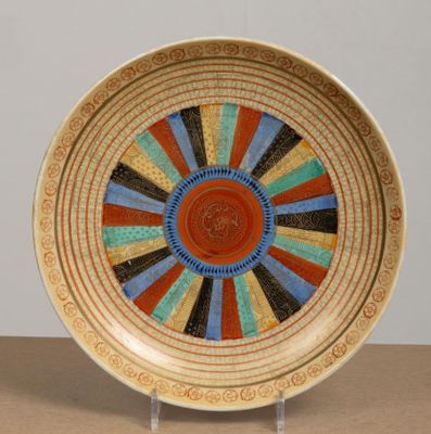 une assiette colorée posée sur un support, sur une table