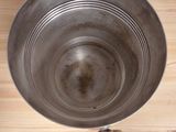 an overhead view of a metal bowl on a wooden table