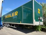 un gros camion vert garé sur le bord de la route