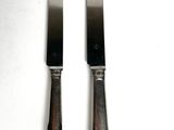 two knives that are sitting next to each other on a table