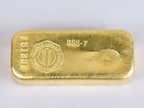 a close up of a gold bar on a white surface