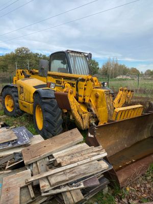 a bulldozer that is parked next to a pile of wood