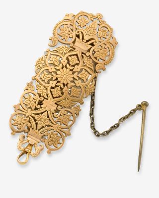 une broche ancienne en or à laquelle est attachée une chaîne