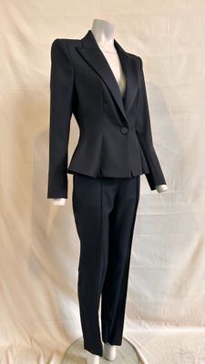 a mannequin wearing a black suit and tie on a stand