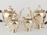 three pieces of silver tea and coffee set on a white surface