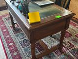 a desk with a glass top and a chair in the room