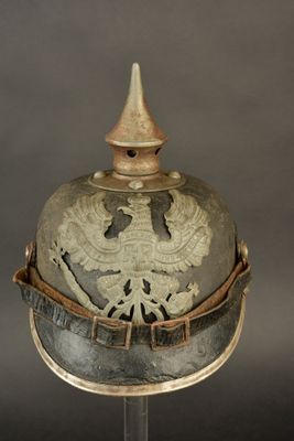 an old helmet with a bird on top of it on a stand