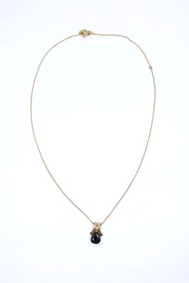 a gold necklace with a black stone pendant on a gold chain