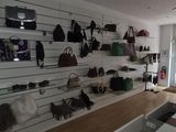 a room with a lot of purses and bags on the wall