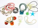 de nombreux colliers et bracelets disposés sur une surface blanche