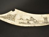 an old knife with a drawing on it sitting on a table