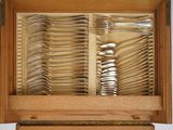 many spoons and forks in a wooden box