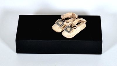 une boîte noire sur laquelle sont posées une paire de chaussures de bébé