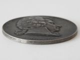 a silver coin with a picture of a man on it