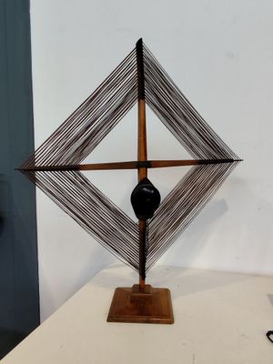 une sculpture représentant un objet noir posé sur une table blanche