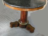 une petite table avec un plateau en marbre posée sur un sol recouvert de moquette