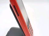 a red cell phone sitting on top of a black stand