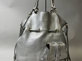 un sac à main argenté dont la poignée est ornée d'un pompon