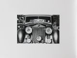 a black and white photo of an old car in a garage