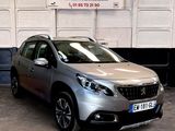 La voiture argentée est garée devant un panneau indiquant « soldes ».