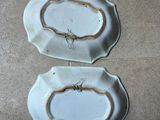 two white plates with a spider on them on a tile floor